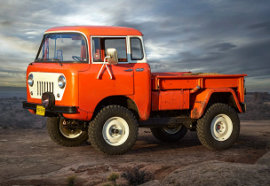 A sideview of a 1957 Jeep FC-150 in red